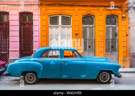 Parked blue vintage car in front of residential house, Havana, Cuba