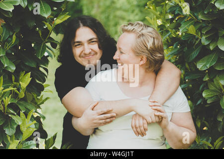 A laughing mother looking at her 18-year old son Stock Photo