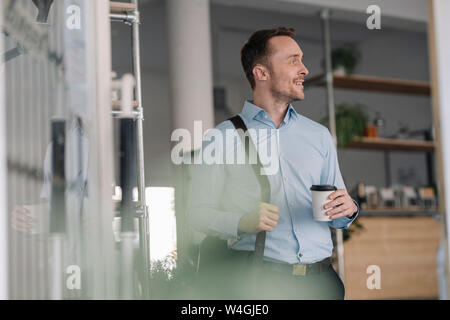 Businessman leaving coffee shope with take out coffee Stock Photo
