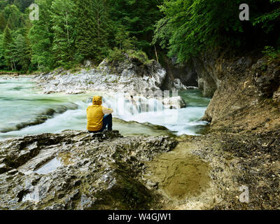 Austria, Tyrol, Brandenberg, hiker sitting on riverside of Brandenberger Ache Stock Photo