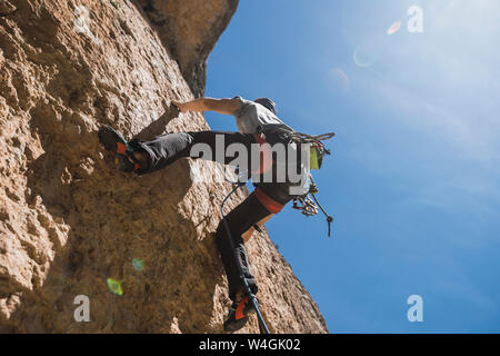 Man climbing in rock wall Stock Photo