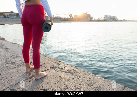 Young woman practicing yoga on the beach Stock Photo