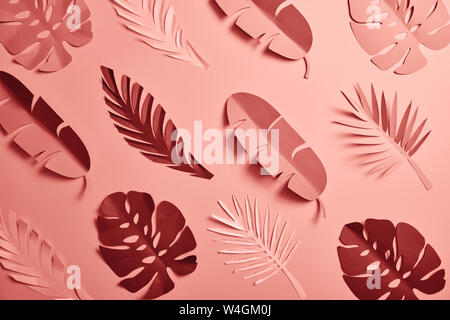 top view of paper cut palm leaves on pink background, seamless pattern Stock Photo