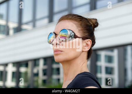 Mature woman wearing welder's goggles in front of an office building Stock Photo