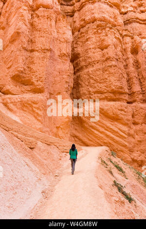 Woman carrying her daughter in a baby carrier walking on path, Bryce Canyon, Utah, USA Stock Photo