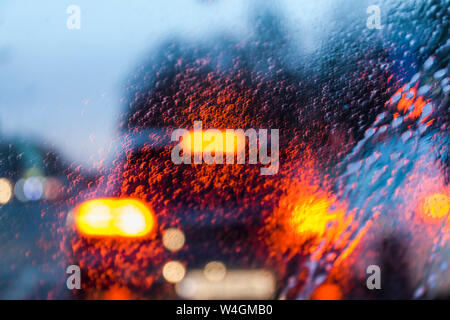 View through windscreen on rainy evening Stock Photo