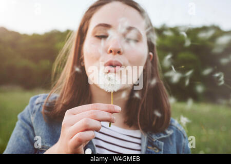 Portrait of teenage girl blowing blowball Stock Photo