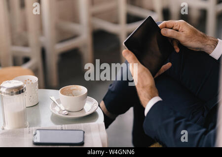 Close-up of businessman using tablet in a cafe Stock Photo