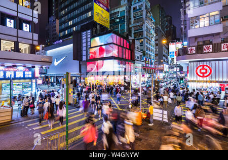 Pedestrians crossing road at night, Mong Kok, Hong Kong, China Stock Photo