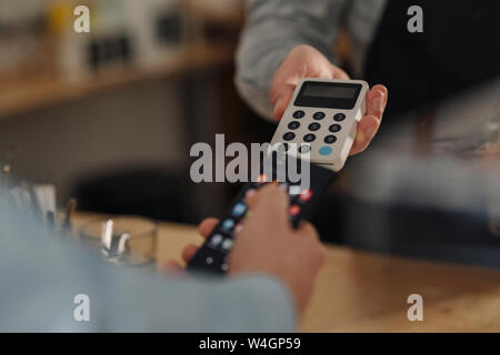 Customer paying contactless in a coffee shop Stock Photo