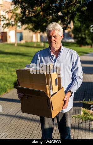 Senior man recycling cardboard carrying cardboard box Stock Photo