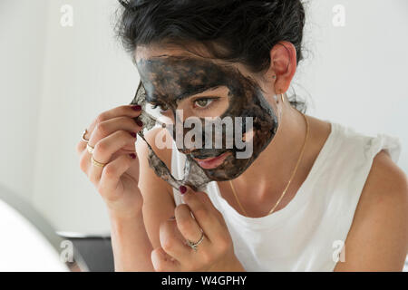 Download Young Woman Removing Facial Mask Reflecting On Mirror Stock Photo Alamy PSD Mockup Templates