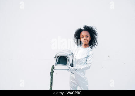 Portrait of little girl wearing space suit in front of white background Stock Photo