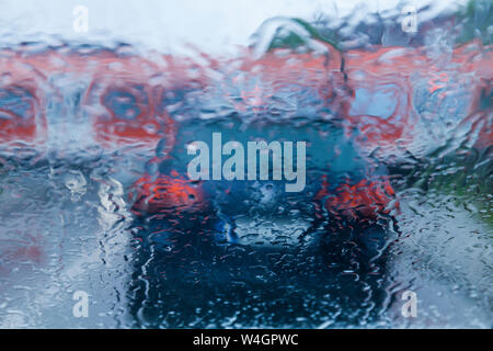 View through windscreen on rainy evening while waiting at level crossing Stock Photo