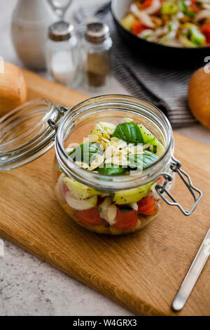 Bowl of salad with herbs, tomatoes, and almonds on the table with ...