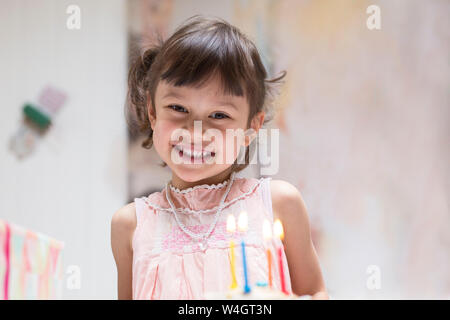 Portrait of happy little girl with burning candles on birthday cake Stock Photo