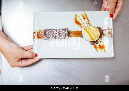Junior chef with prepaired dessert on plate, from above Stock Photo