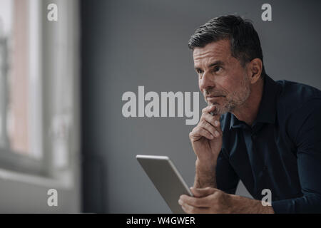 Portrait of mature businessman holding tablet Stock Photo