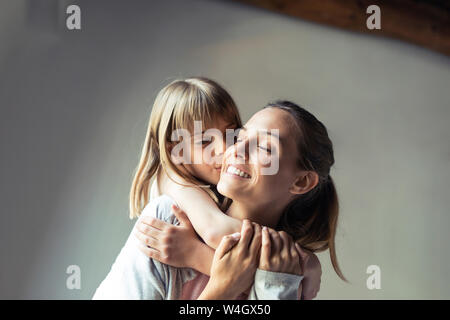 Mother and daughter playing at home, piggyback Stock Photo