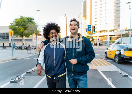 Two happy friends walking in the city, Barcelona, Spain