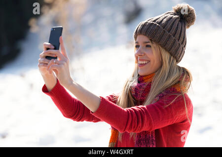 Young blond woman taking a selfie in winter Stock Photo