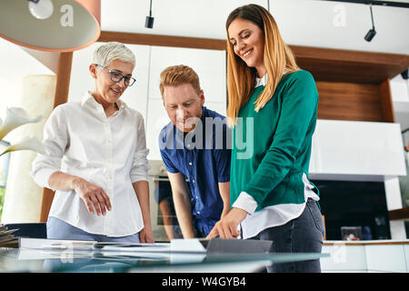 Couple shopping for a new kitchen in showroom looking at papers Stock Photo