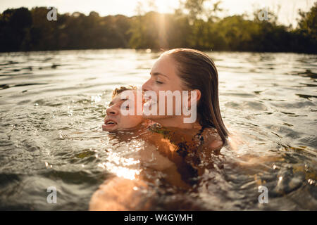 Affectionate couple swimming together in a lake Stock Photo