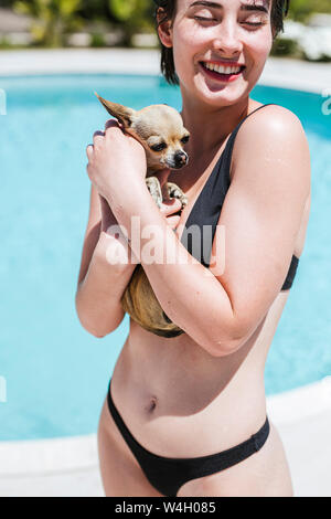 Young women with chihuahua at the pool Stock Photo