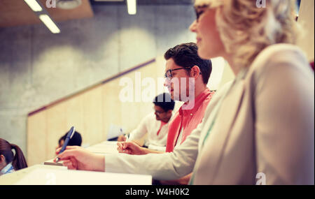 group of students with notebooks in lecture hall Stock Photo