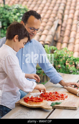 Father and son preparing pizza together Stock Photo