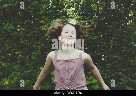 A girl jumping with her eyes closed Stock Photo