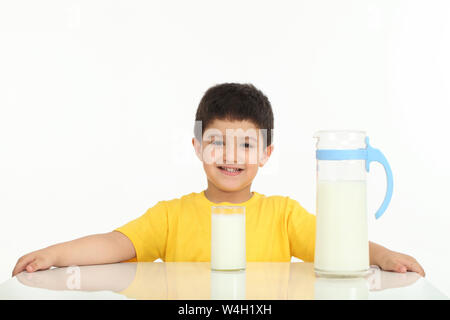Portrait of a boy smiling with a glass of milk in front of him Stock Photo