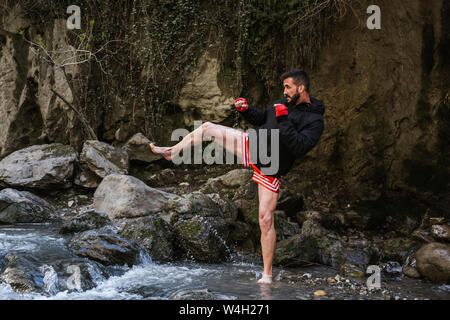 Young man doing boxing workout in nature Stock Photo