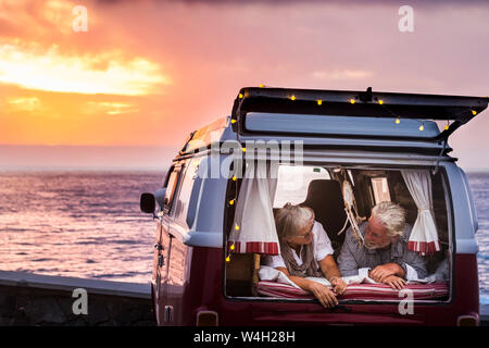 Senior couple traveling in a vintage van, lying in boot Stock Photo