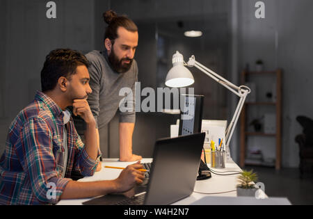 creative team with computer working late at office Stock Photo