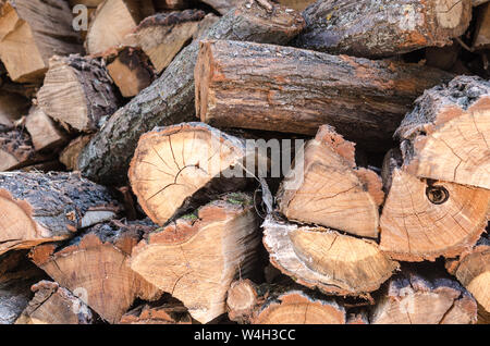 Pile of stacked triangle firewood prepared for fireplace and boiler. Background with pile of firewoods. Closeup of firewoods in the yard - pile of cho Stock Photo