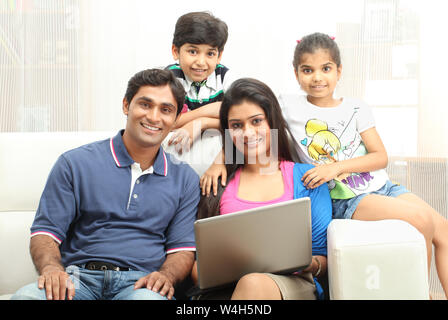 Family using a laptop and smiling at home Stock Photo
