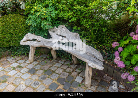 Bench seat made from old gnarled tree trunk - France. Stock Photo