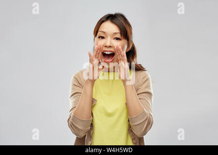 young asian woman calling for someone Stock Photo