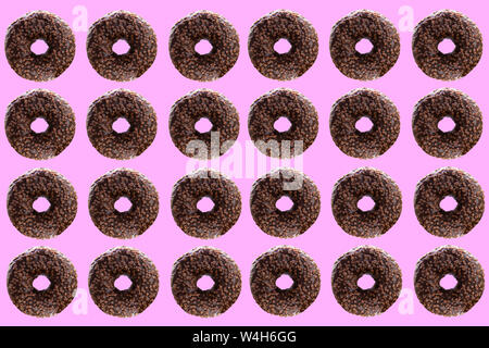 Chocolate donuts on a pink background. Cheerful, festive background and seamless texture. Stock Photo