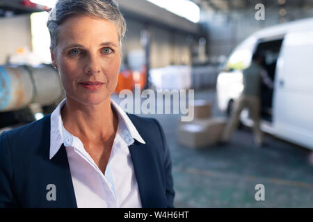 Happy female manager looking at camera in warehouse Stock Photo