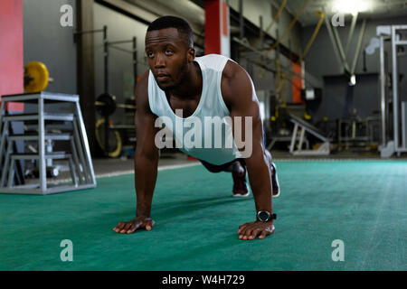 Male athletic exercising in fitness center Stock Photo
