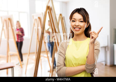 happy asian woman pointing finger up Stock Photo