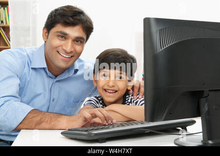 Man with his son using a computer at home Stock Photo