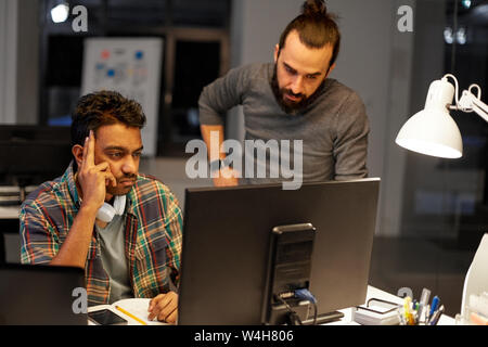 creative team with computer working late at office Stock Photo