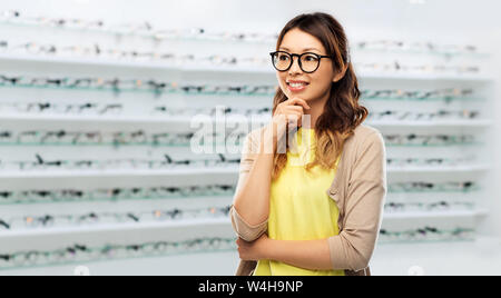 happy asian woman in glasses over optics store Stock Photo