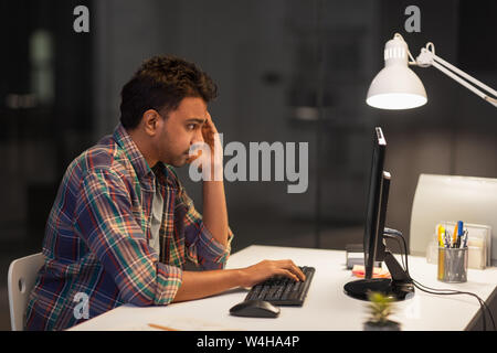 creative man with computer working at night office Stock Photo