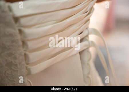 Wedding dress being done up on a Brides wedding day, close up of wedding dress being done up before the ceremony Stock Photo