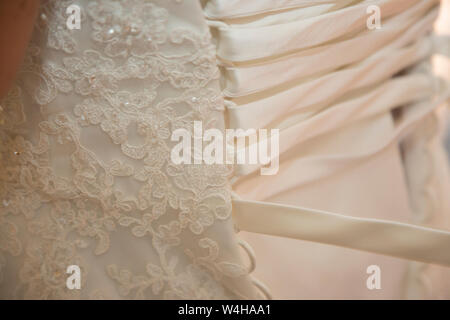 Wedding dress being done up on a Brides wedding day, close up of wedding dress being done up before the ceremony Stock Photo