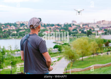 Young Man watching and navigating a flying drone. Stock Photo